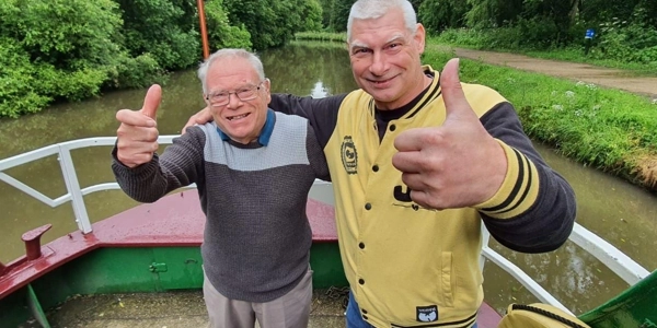 Image of two men on a boat with their thumbs up